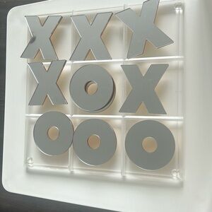 Lucite and mirror tic tac toe board. 12x12 with reversible gold/silver pieces.